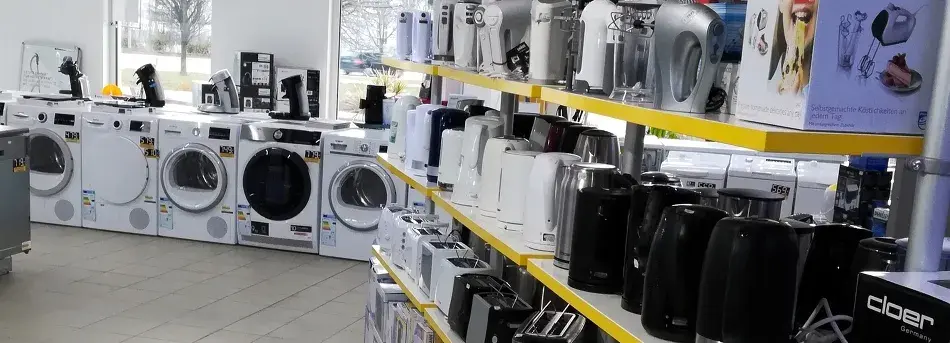 Elektrofachgeschäft mit Waschmaschinen und kleinen Haushaltsgeräten auf Regalen